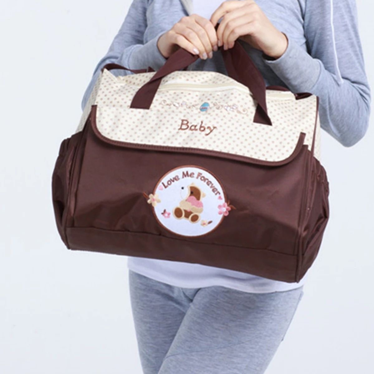 Sac pour la maternité marron tenu à la main, vue frontale en situation