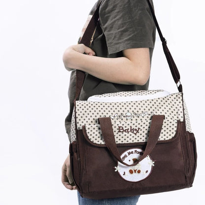 Sac pour la maternité marron porté à l’épaule par un parent, vue latérale