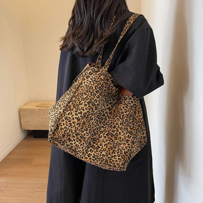 Sac pour la maternité léopard brun porté avec manteau noir, vue arrière gauche