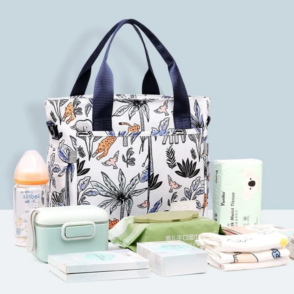 Sac pour maternité jungle colorée posé avec accessoires bébé devant